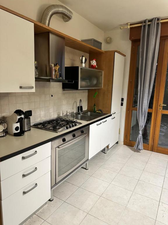 a kitchen with white cabinets and a stove top oven at Marias House in Rimini