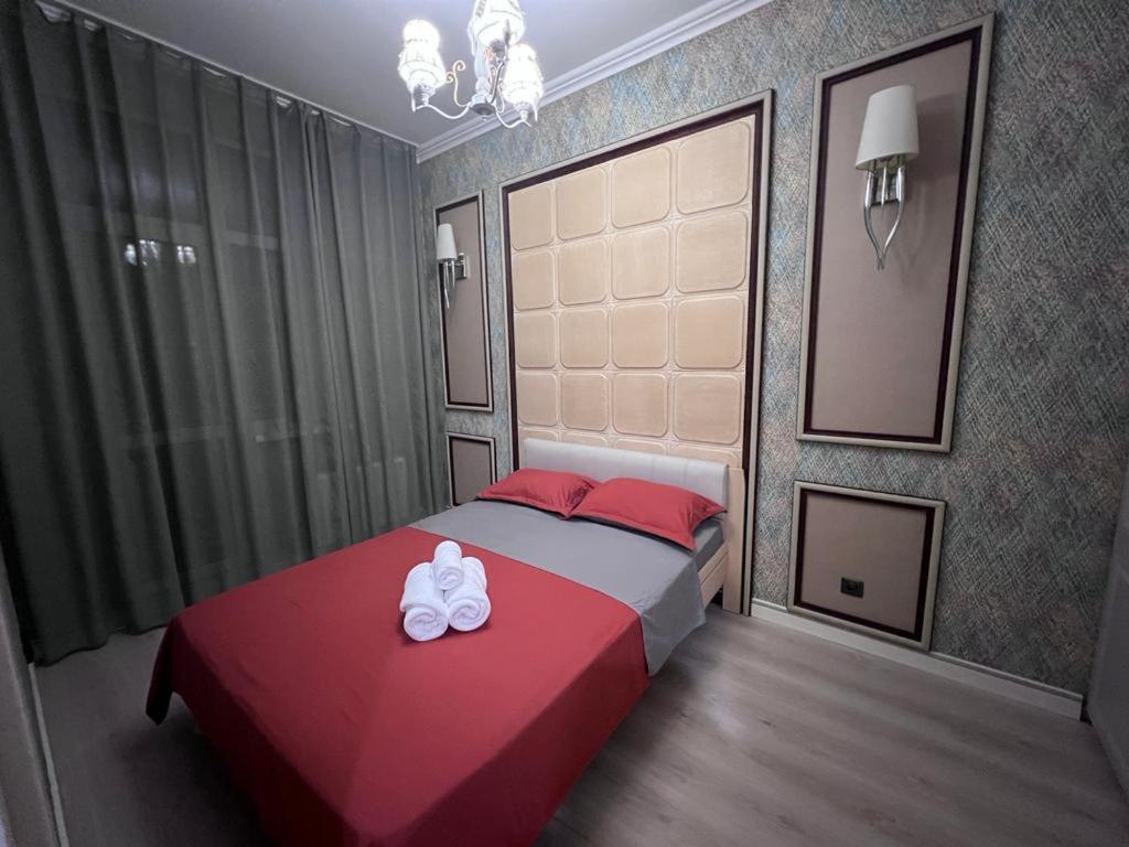 - une chambre dotée d'un lit avec deux chaussures blanches dans l'établissement Набережная Астаны, à Astana