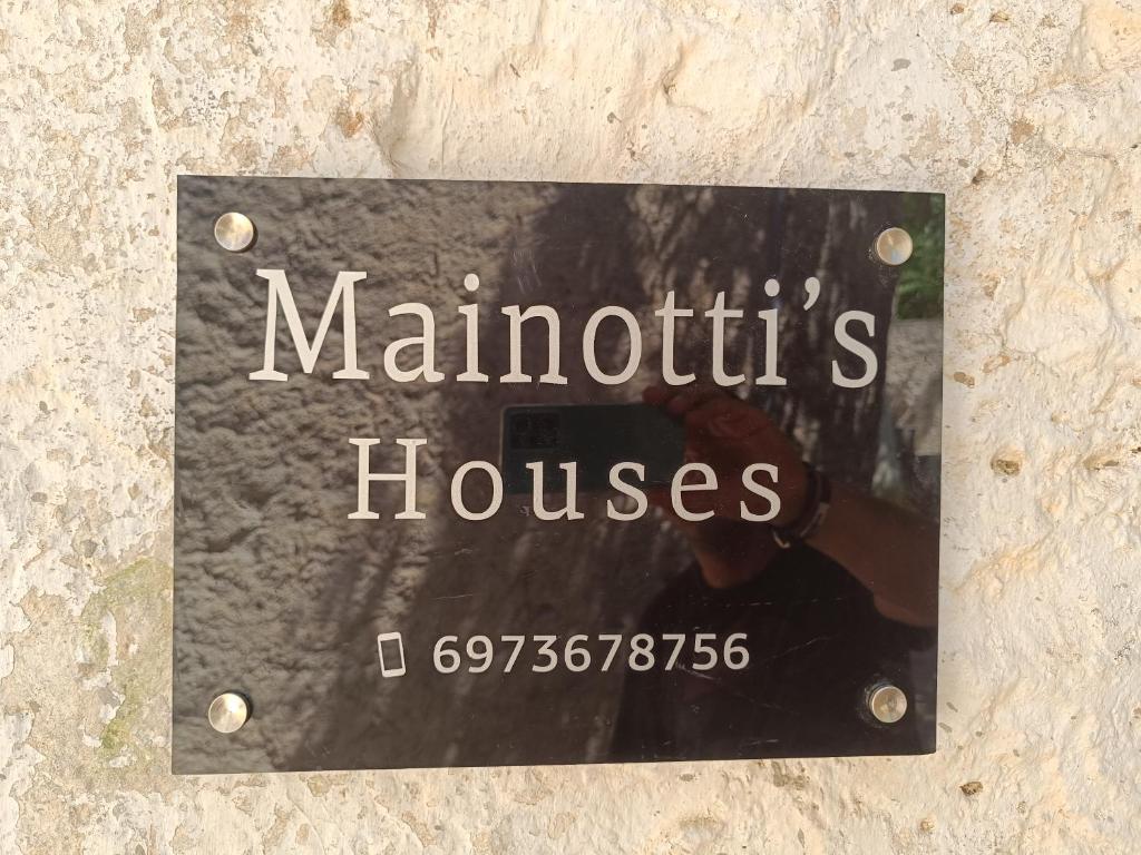 una señal de casas maruthtis en una pared en Mainotti's house, en Areopoli