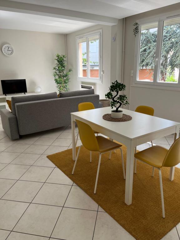 een woonkamer met een witte tafel en stoelen bij Zénith de Rouen - Sud 3 - Diochon - Parc Expo in Le Grand-Quevilly