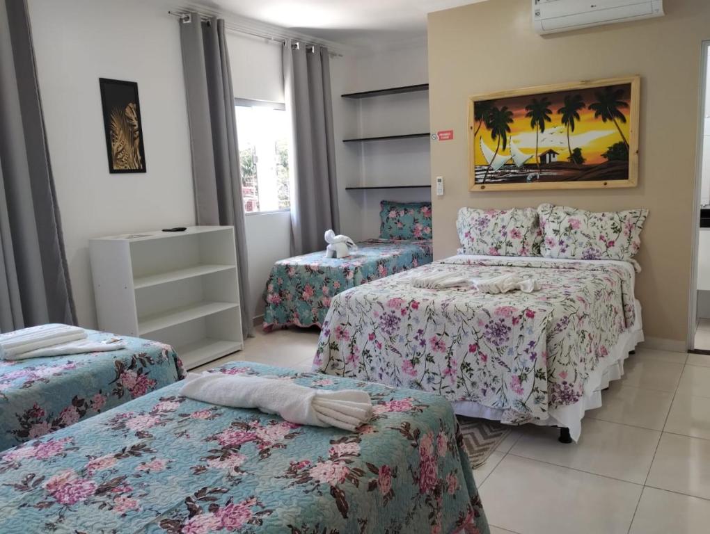 een slaapkamer met 3 bedden en een raam bij Pousada La Belle in Maragogi