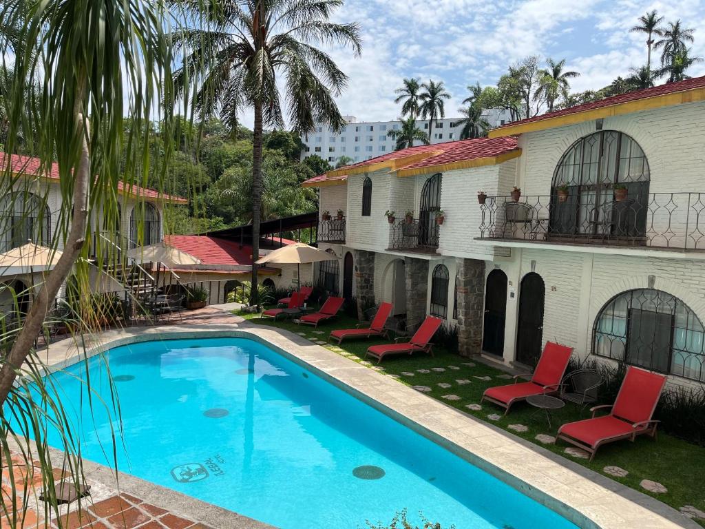 una piscina frente a un edificio con palmeras en Hotel Ilebal en Cuernavaca