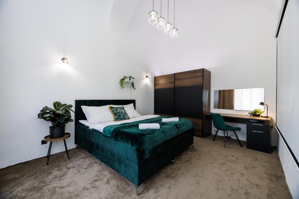 a bedroom with a bed and a desk and a chair at SPAYA JACUZZI centrum apartment - with home cinema & private parking in Košice