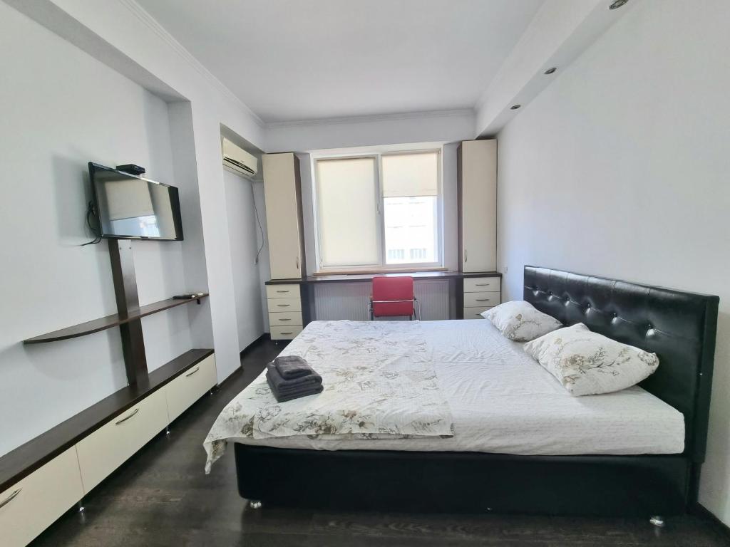 a bedroom with a bed and a tv in it at Testemiteanu 1 bedroom apartment with work zone in Chişinău