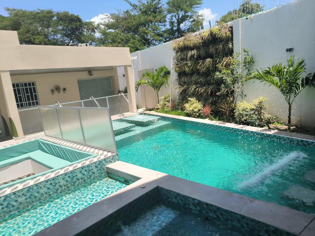 a swimming pool in front of a house at Villa campestre Meqo in Ríohacha