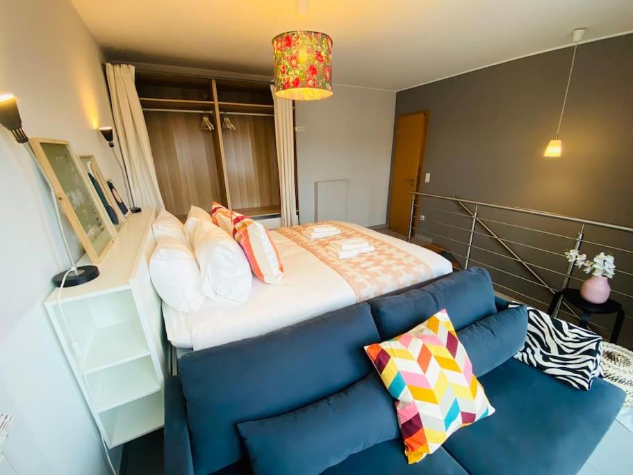 a bedroom with a bed and a blue couch at Charming Apartments in City Center - S6 in Luxembourg