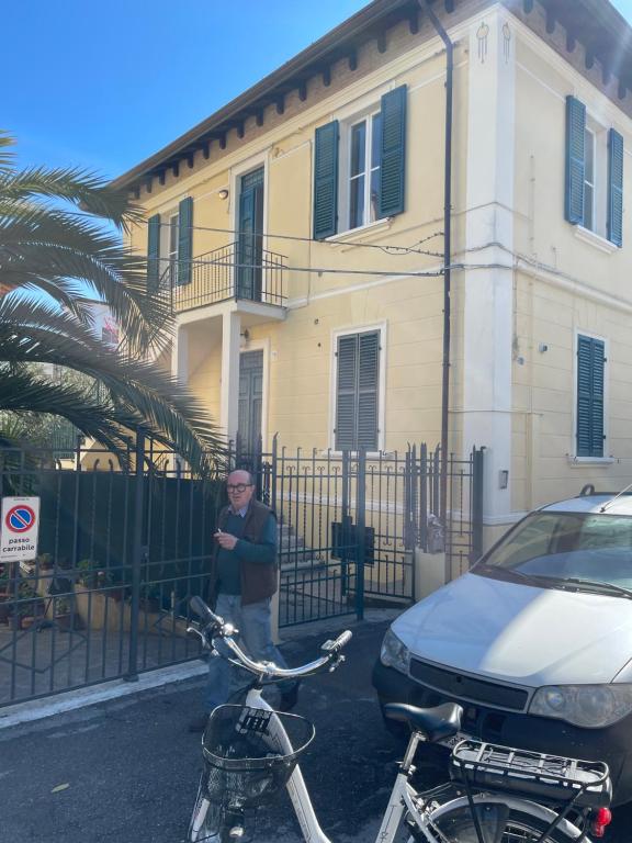 een man die voor een huis staat met twee fietsen bij Casa Mare Vacanze Viale Venezia 20 Pesaro NUOVA in Pesaro