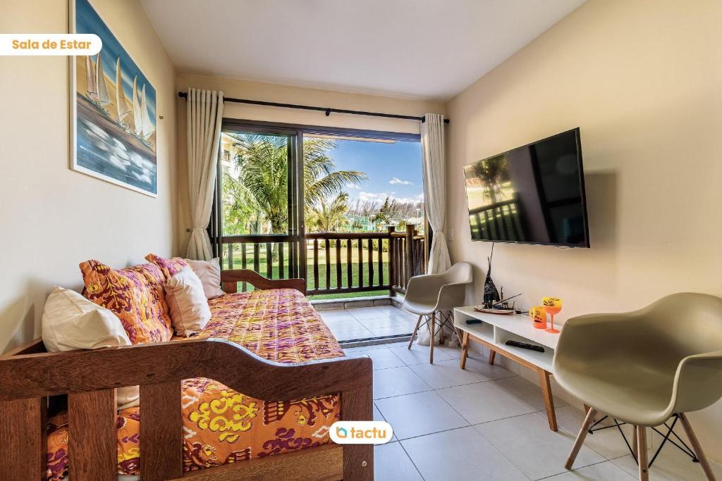 - une chambre avec un lit, une télévision et un balcon dans l'établissement Rez-de-chaussée VG Sun Cumbuco par Tactu, à Paracumbuca