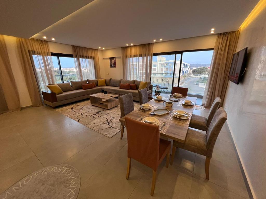 a living room with a table and a couch at Appartement de luxe bord de Mer Essaouira à 2 pas de la plage in Essaouira