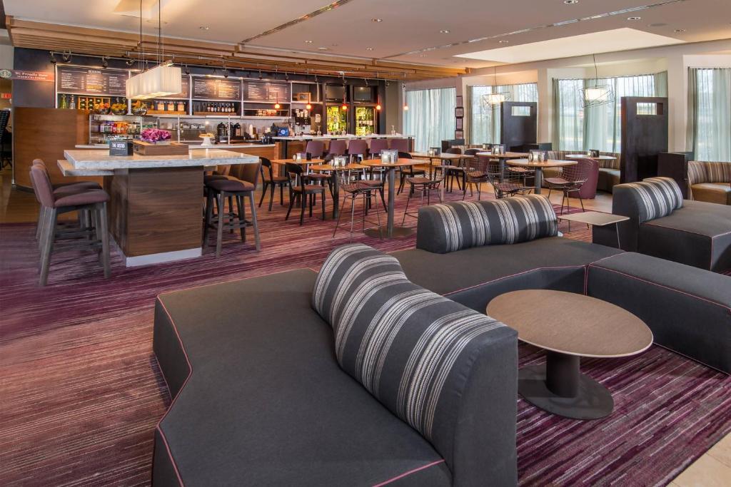 a restaurant with couches and tables and a bar at Courtyard by Marriott Fairfax Fair Oaks in Fairfax