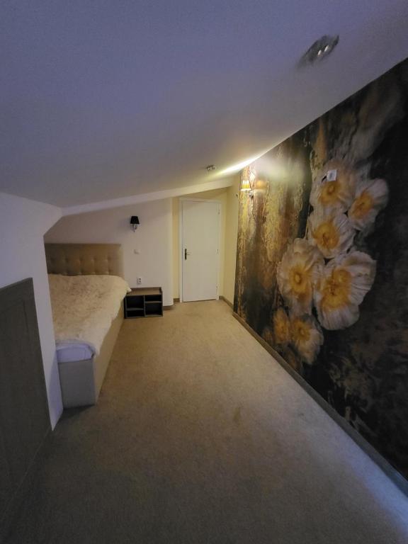 ein Schlafzimmer mit einem Bett und einem Blumengemälde an der Wand in der Unterkunft Vila Marija in Ribarska Banja