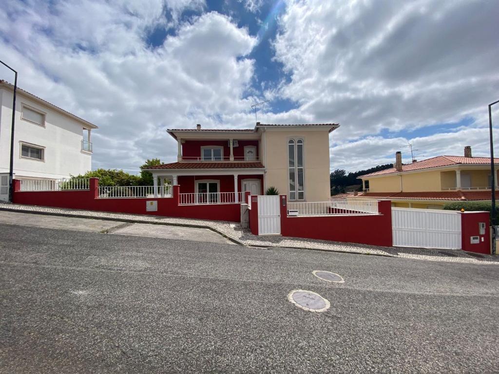 a red fence in front of a house at Amazing Scorpion´s House Leiria in Leiria