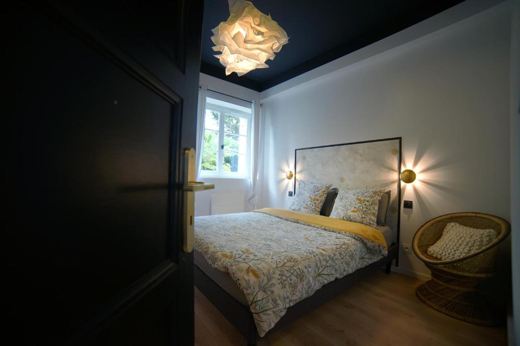 une chambre avec un lit, une fenêtre et un lustre dans l'établissement Monseigneur Dijon central & design avec parking, à Dijon