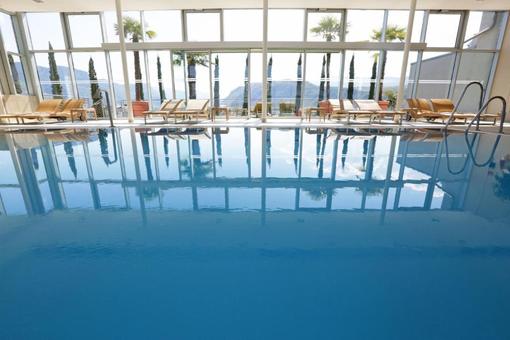 basen z krzesłami i stołami w budynku w obiekcie Four Points Sheraton Bolzano Bozen w mieście Bolzano
