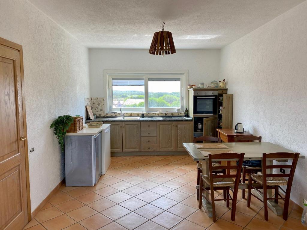 uma cozinha com mesa e cadeiras e uma janela em Li Lucianeddi em Buoncammino