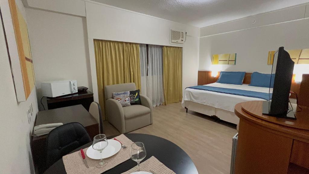 um quarto de hotel com uma cama e uma sala de estar em Flat c/ Garagem na Rua Borges Lagoa 1179 UH518 em São Paulo