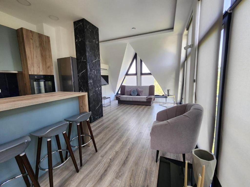 a living room with a bar and some chairs at LUX Apartman Simi in Divčibare
