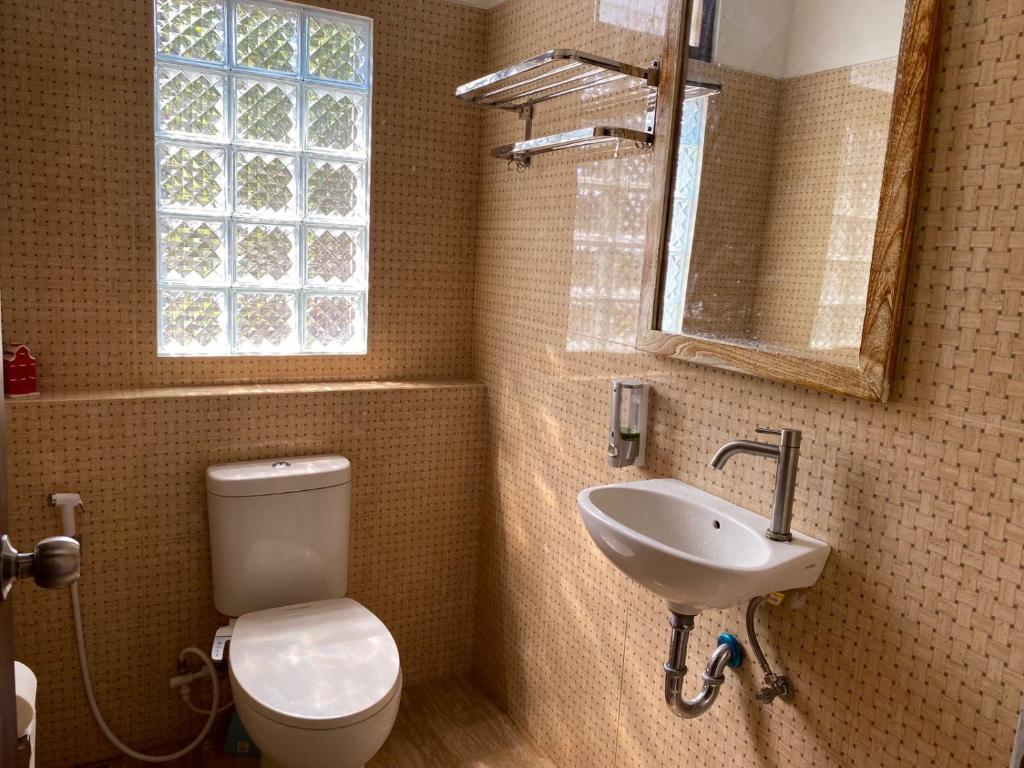 ein Bad mit einem WC, einem Waschbecken und einem Fenster in der Unterkunft Rumah Yosua in Palbapang