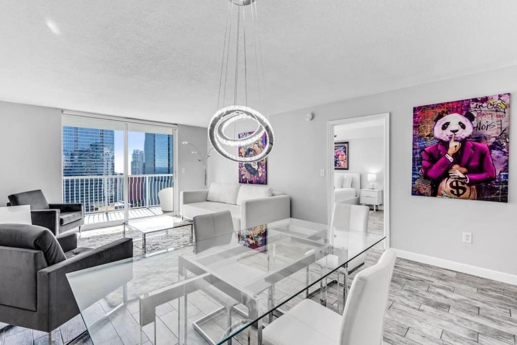 un soggiorno con un tavolo da pranzo in vetro di Majestic Penthouse with Ocean and City Views a Miami