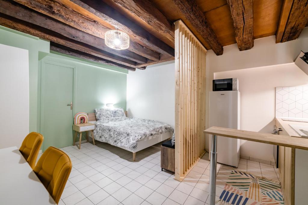 sypialnia z łóżkiem, stołem i lodówką w obiekcie Le cosy de Tonnerre w mieście Tonnerre