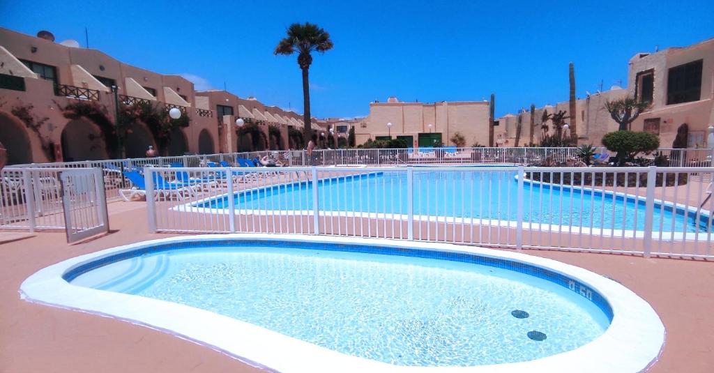a large swimming pool with a fence around it at Castillo Mar 95 in Caleta De Fuste