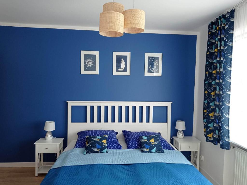 a blue bedroom with a bed with blue walls at Szanta in Jastarnia