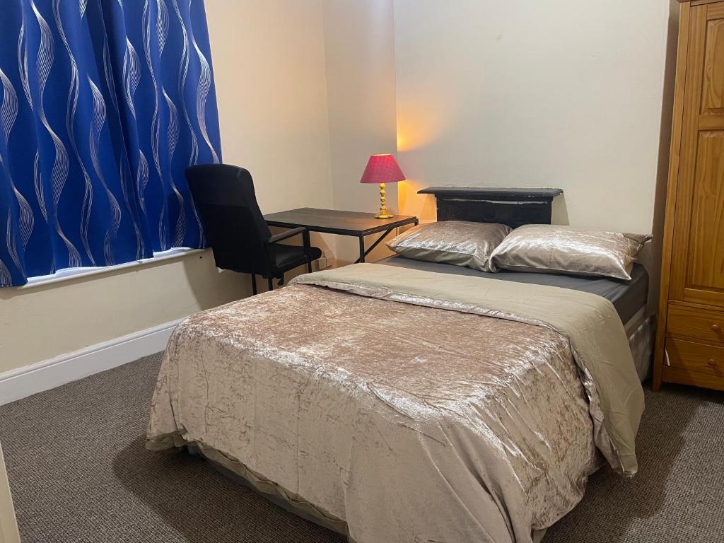 a bedroom with a bed and a desk with a chair at Transformative housing Laurie avenue in Nottingham