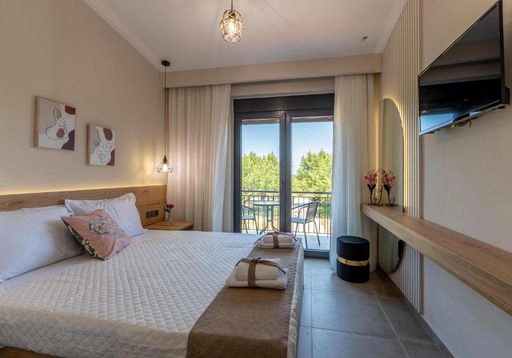 1 dormitorio con 1 cama grande y balcón en Fragkos Doukas Rooms en Kamariotissa