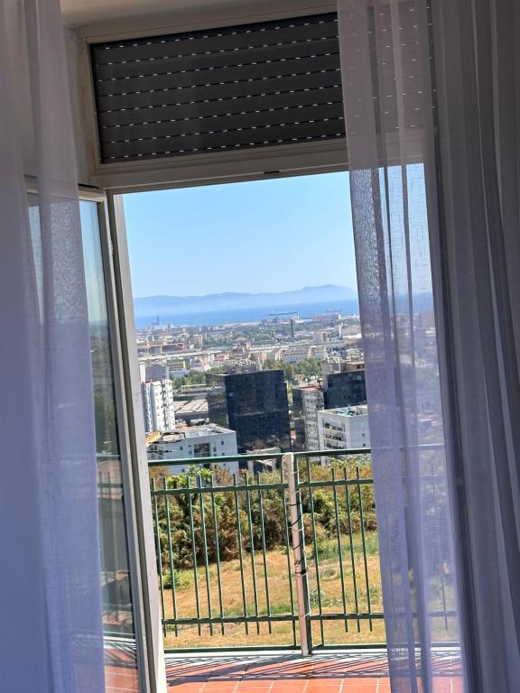 a window with a view of a city at Airport Seaview Rooms in Naples