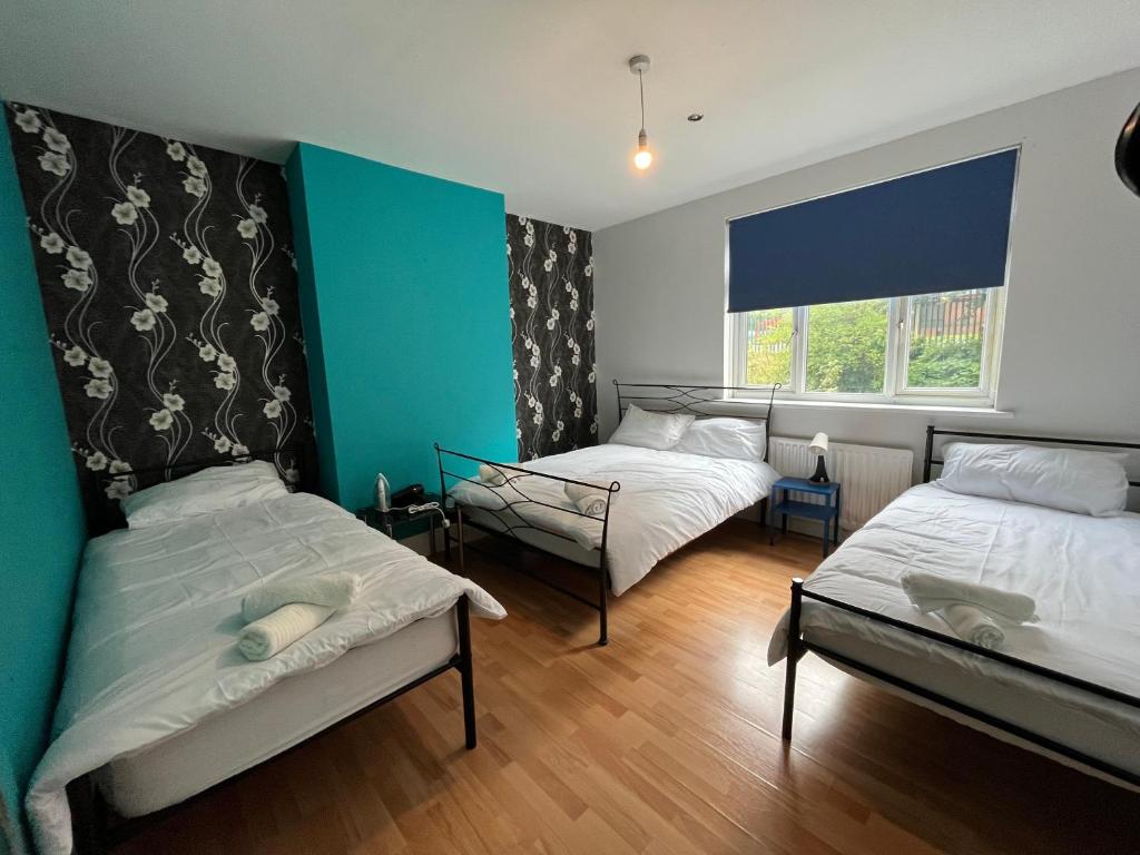 a room with two beds and a window at 2 bedroom apartment, 5 minutes from city centre in Newcastle upon Tyne