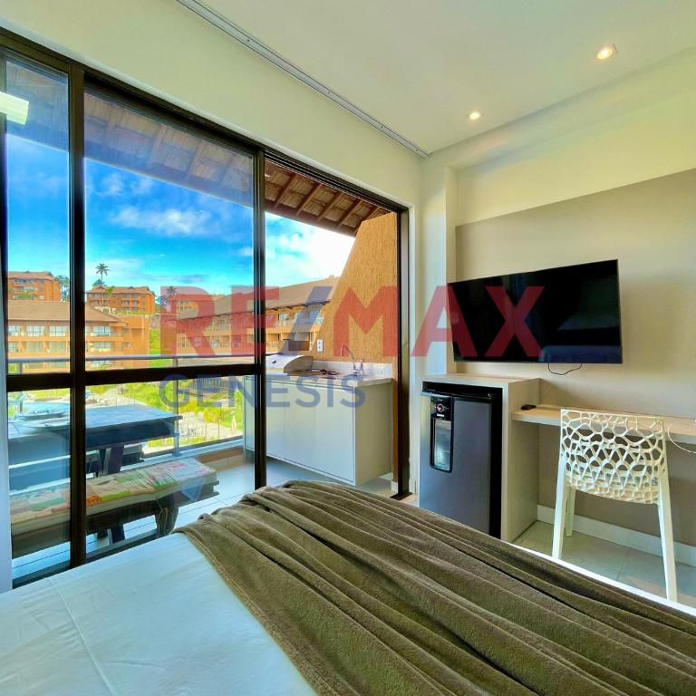 a bedroom with a bed and a desk and a television at 207 EM Eco Resort in Tamandaré