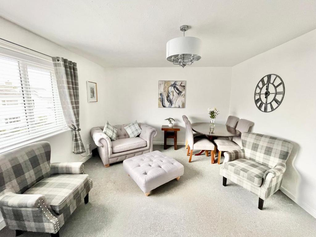 a living room with couches and a table at Cae Glas Apartments in Holyhead