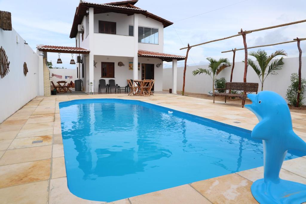 a villa with a swimming pool in front of a house at Canoa Quebrada House in Canoa Quebrada