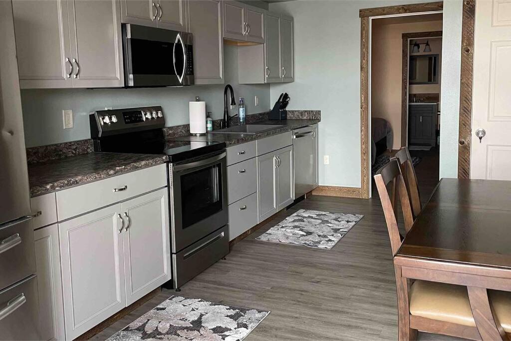 a kitchen with stainless steel appliances and a table at ParkWay Yellowstone Guest House #7 in Gardiner