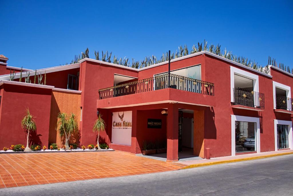 een rood gebouw met een balkon erboven bij Hotel Casa Real Cholula in Cholula