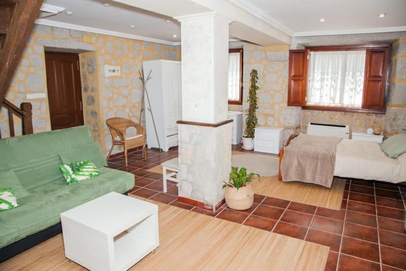 ein Wohnzimmer mit einem grünen Sofa und ein Wohnzimmer mit einem Herd in der Unterkunft Casa Donas in Gondomar
