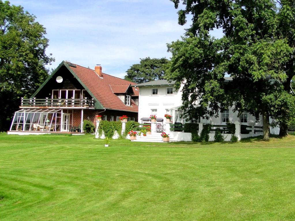 uma grande casa branca com um grande quintal em Pommernhof em Ustronie Morskie