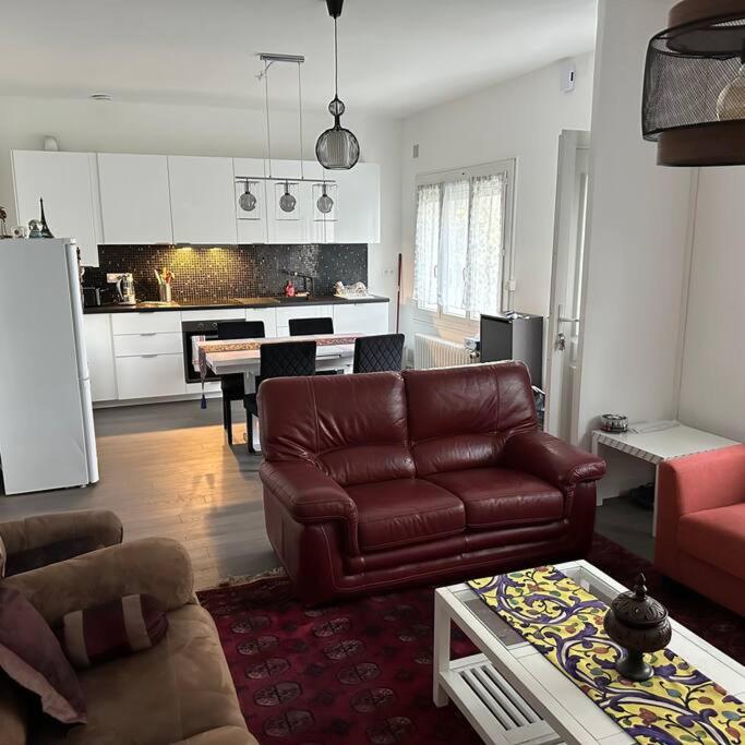 A home away from home في رين: غرفة معيشة مع أريكة جلدية بنية ومطبخ