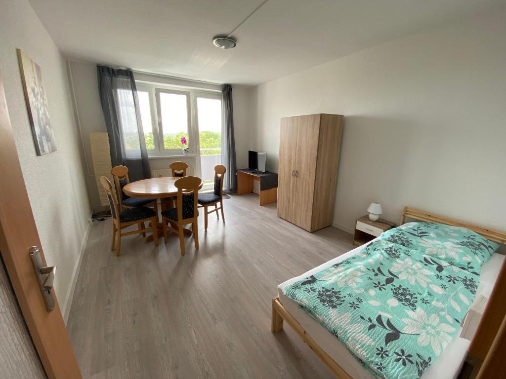 Un dormitorio con una cama y una mesa y sillas. en Monteur und Ferienwohnung TMS 18 M, en Wefensleben