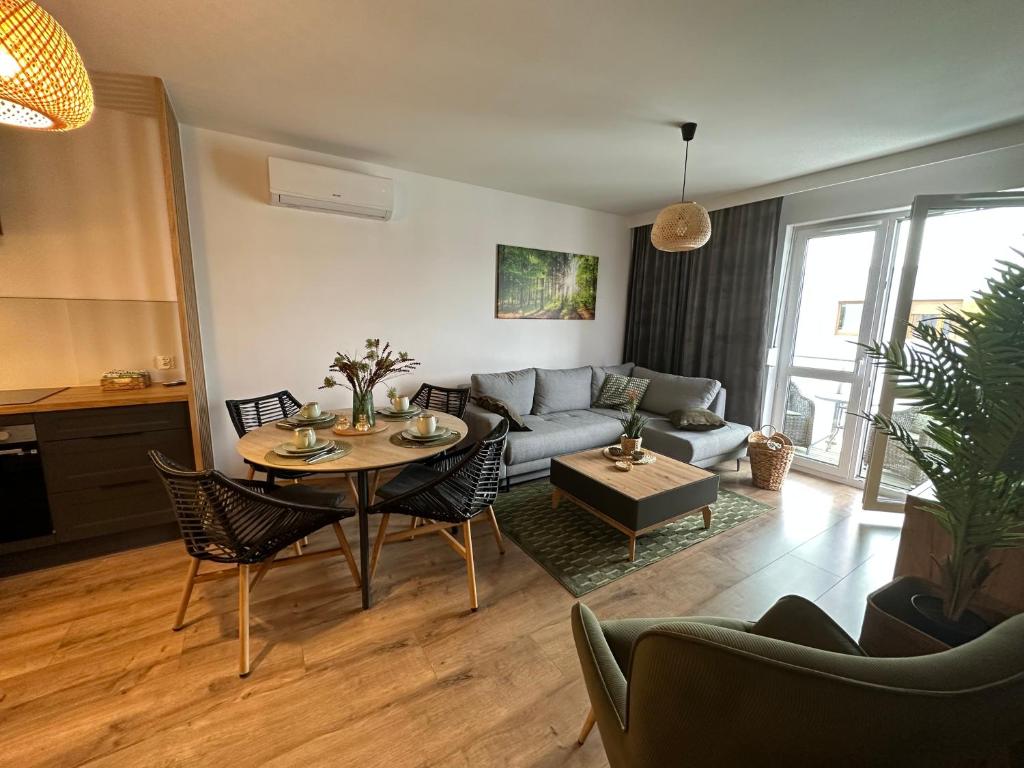 een woonkamer met een bank en een tafel bij Apartament 28 w Dolinie Baryczy - 5D Apartamenty in Milicz