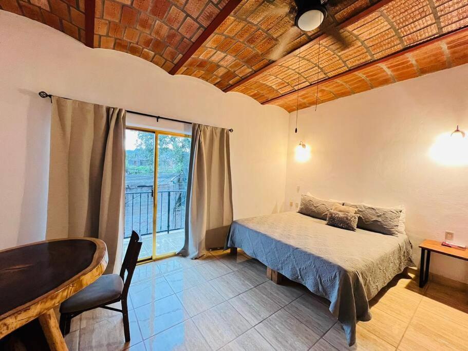 ein Schlafzimmer mit einem Bett und einem großen Fenster in der Unterkunft Casa San Marcos in Lo de Marcos