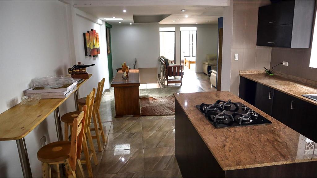 uma cozinha e sala de estar com um balcão e uma ilha de cozinha em Hostal Casa Amatista em Pereira