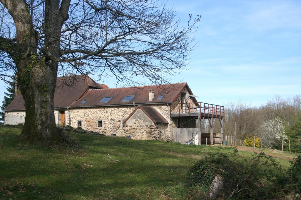 une ancienne maison en pierre avec des panneaux solaires sur une colline dans l'établissement Gite Fleurs d'Esse, à Saint-Paul-la-Roche
