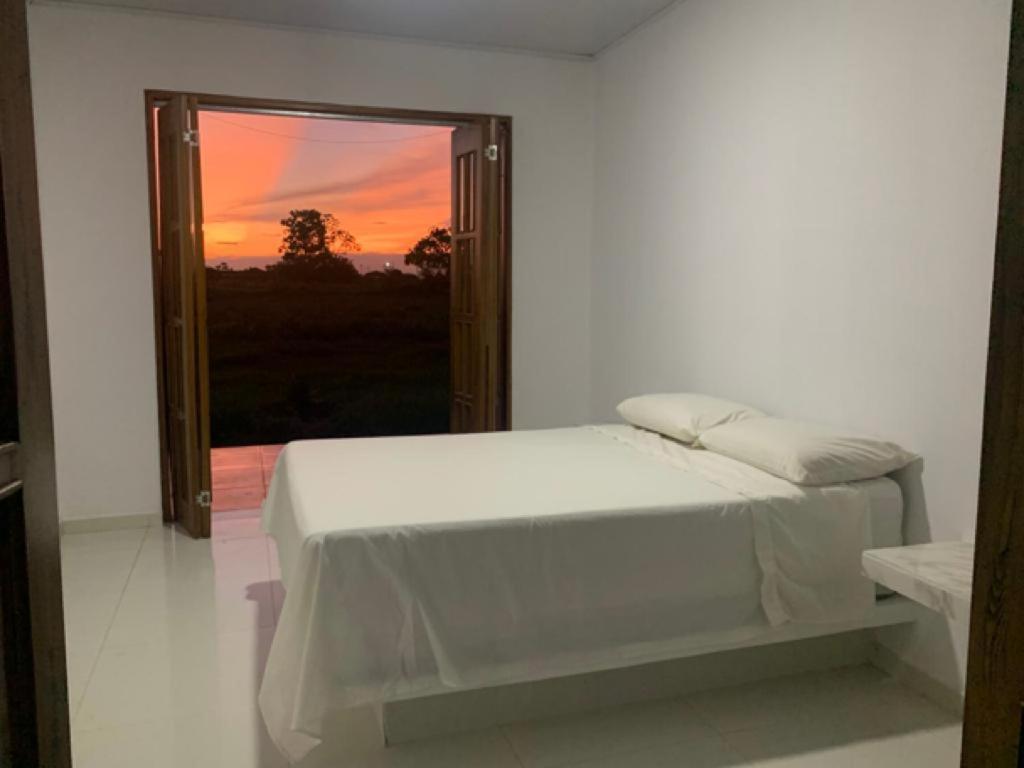 een witte slaapkamer met een bed en een raam bij Mi finca en el llano in La Floresta
