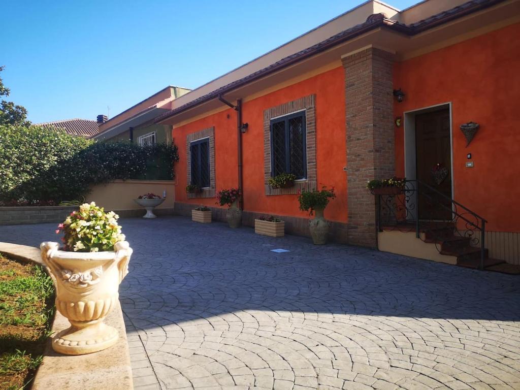 ein orangefarbenes Gebäude mit einer Blumenvase davor in der Unterkunft La dimora di Massimo in Ponte Lucano