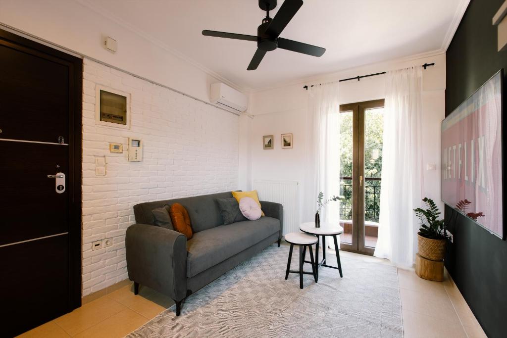 a living room with a couch and a ceiling fan at Upper city suite in Thessaloniki