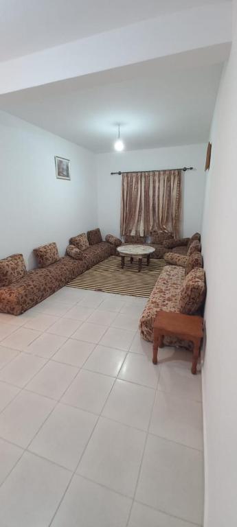 a living room with couches and a table in it at Appartement à louer uniquement pour les familles in Al Hoceïma
