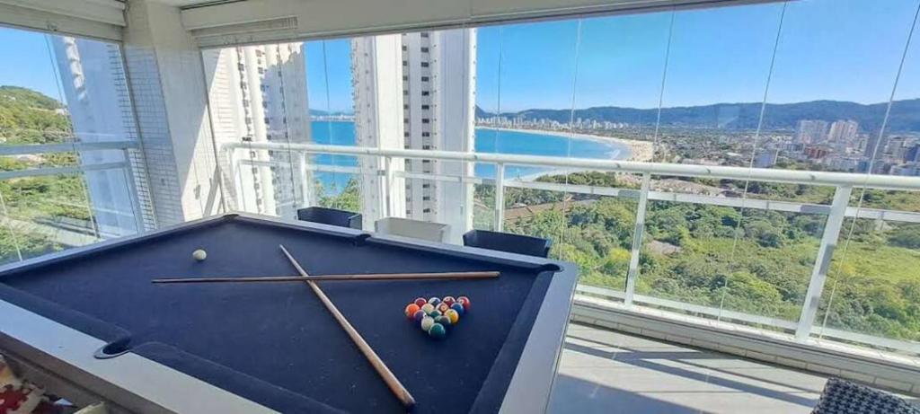 a pool table in a room with a view of a city at Recanto das Tartarugas - Guarujá in Guarujá