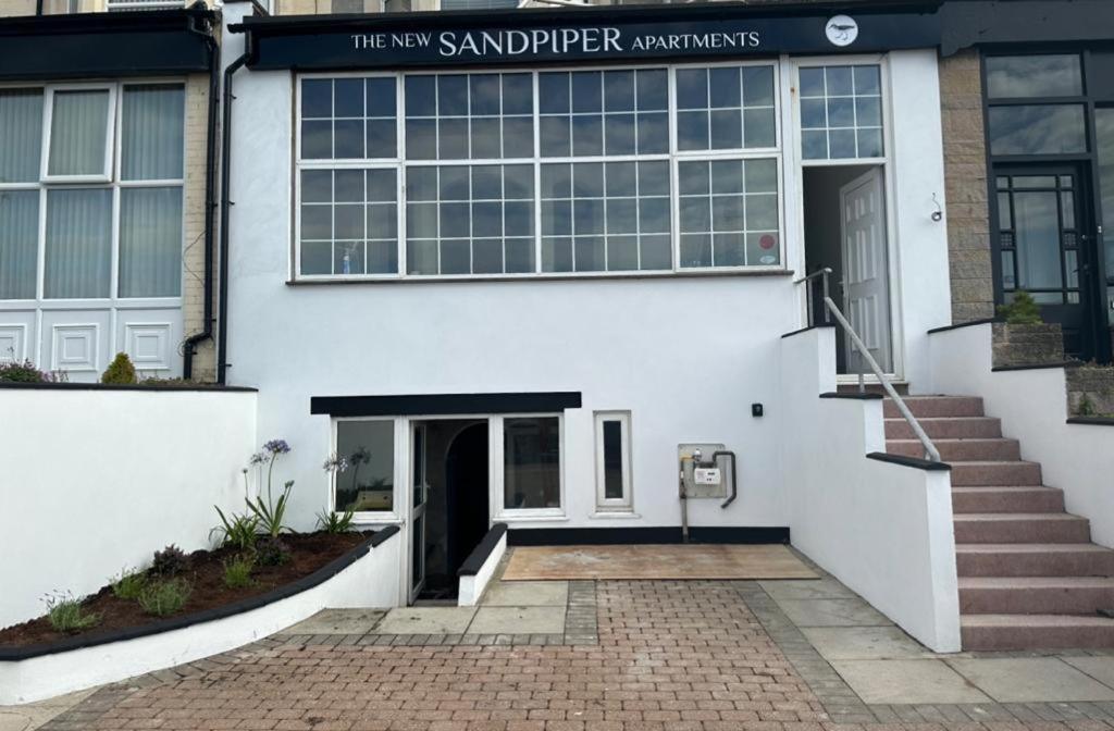 um edifício branco com entrada para os novos apartamentos sandpper em New Sandpiper Apartments em Fleetwood