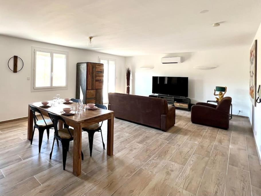 a living room with a table and a couch at Le Saint-Jalmes P2 + Parking in Nîmes